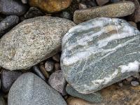 Grauer Stein mit weißen Einschlüssen neben hellgrauen Stein mit Vertiefungen